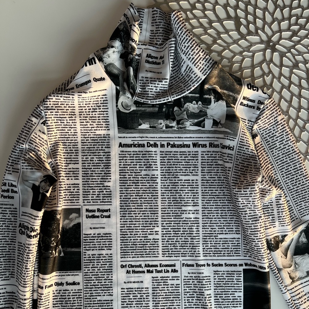 BALENCIAGA
Newspaper Print Stretch Trutleneck Top In White/black